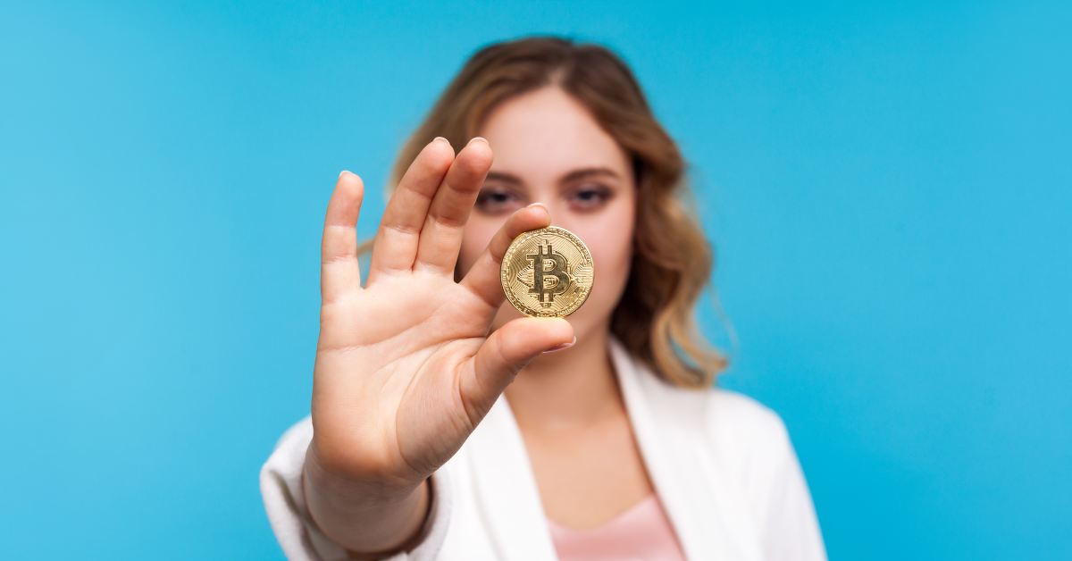 Cropped photo of a girl in bra who holds bitcoin golden coind in