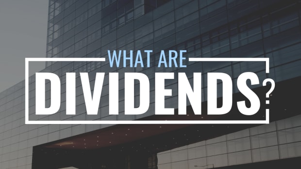 Darkened photo of a large office building with stylized text overlay that reads "What Are Dividends?"