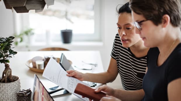 Two women are seen analyzing their taxes and finances. -lead