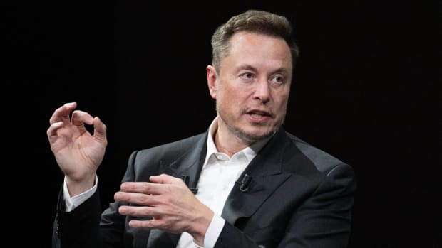 Elon Musk, Tesla CEO, is seen gesturing while engaged in conversation. -lead