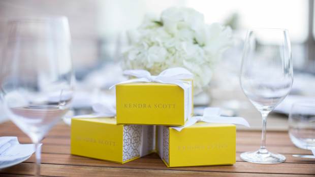 Boxes of Kendra Scott jewelry on a table.