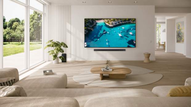 Samsung's new for 2024 98-inch DU9000 Crystal UHD TV hanging on a wall in a living room.