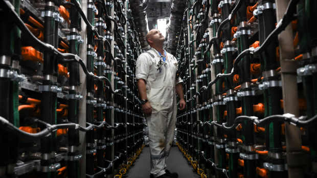 An engineer member of staff looks at the XALT Energy batteries of a capacity of up to 8.8 MWh placed in the battery room of the Hybrid Ferry ship P&O Liberte, docked in the port of Dover, southern England, on March 14, 2024. P&O Liberte and its sister ship Pioneer will be able to accommodate up to 15,000 passengers and 800 lane metres for cars. The new ferries will incorporate electric battery technology, reducing emissions and minimising environmental impact. To recharge the batteries efficiently, Calais and Dover terminals will have to be equipped with giant 40-megawatt charging stations. Calais, will benefit from being close to a nuclear power station, whilst for Dover, work will required to create high voltage lines to enable full use to be made of electric ferries. (Photo by Daniel LEAL / AFP) (Photo by DANIEL LEAL/AFP via Getty Images)