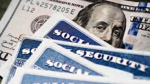 Social Security cards are pictured with a U.S. $100 bill. -lead