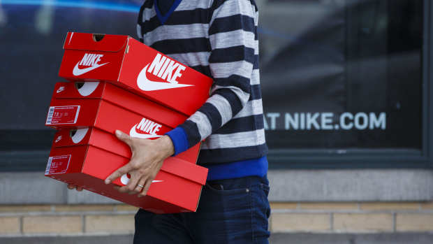 A customer carries boxes of Nike Inc. shoes outside of the NikeTown Los Angeles retail store in Beverly Hills, Calif. Photographer: Patrick T. Fallon/Bloomberg via Getty Images