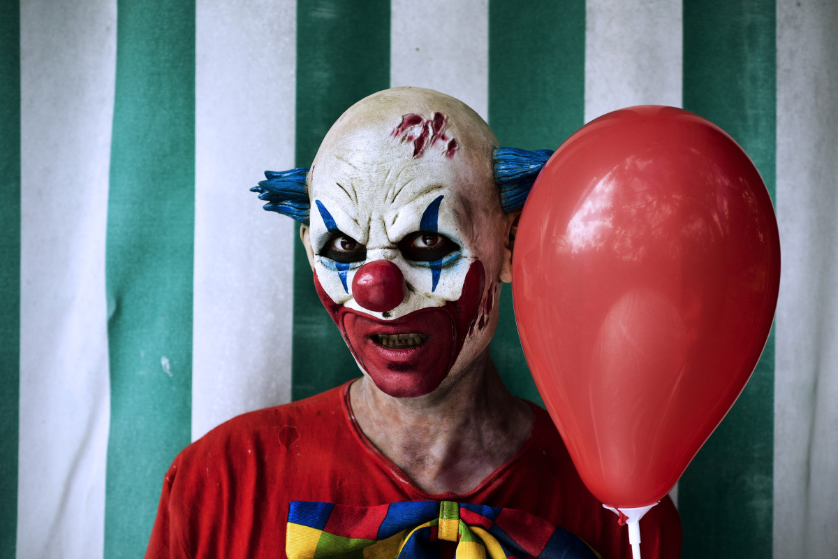 Laughing clowns. Мрачный клоун дарит шарик.